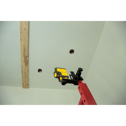 STANLEY STHT77503-1 laser level attached to red ladder during ceiling installation.