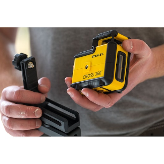 Photo of STANLEY STHT77504-1 CROSS 360 laser level with mounting bracket, held in hands.