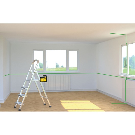 STANLEY STHT77594-1 laser level projecting green lines in a bright room, shown from front angle with ladder.