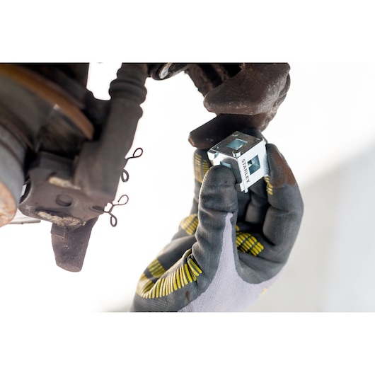 STANLEY STHT80883-0 photography of metal tool held by gloved hand near automotive part.