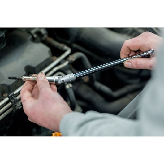 STANLEY STHT81016-0 socket wrench extension used for automotive repair, close-up showing hand operation.