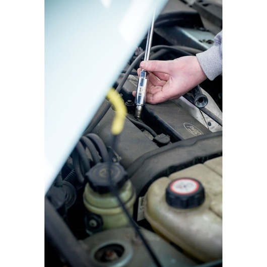 STANLEY STHT81583-0 test screwdriver used on car engine, close-up photo of tool in automotive setting.