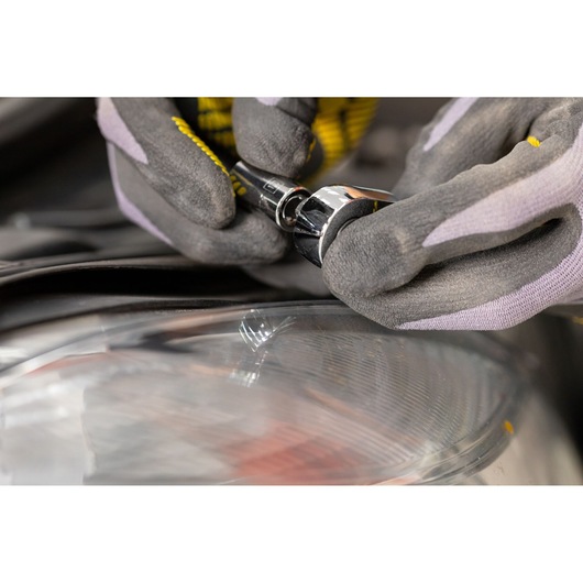 STANLEY STMT82672-0 socket being used by gloved hands near a car headlight, close-up photo.