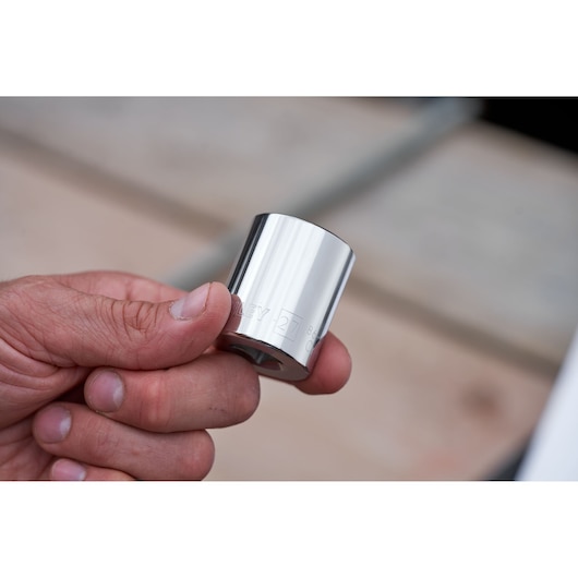 Hand holding a STANLEY chrome socket from STMT82831-1 ratchets and socket set, close-up view.