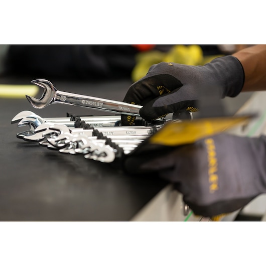 Photo of STANLEY STMT82847-0 wrench set with gloved hand picking a chrome wrench from a black holder.