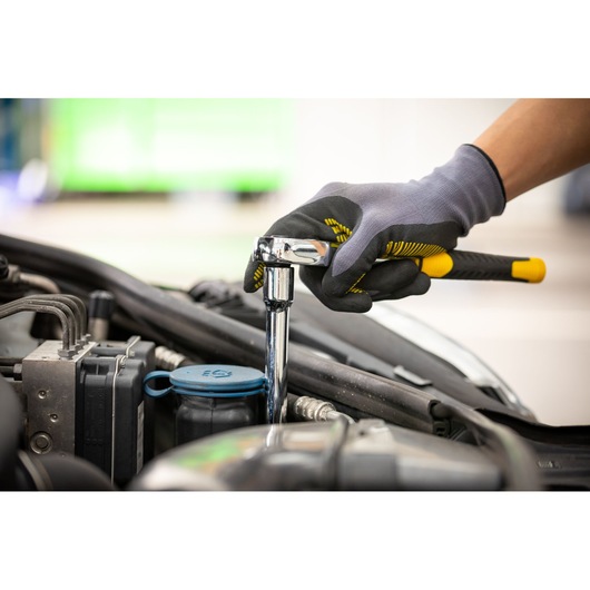 Stanley STMT86007-0 ratchet wrench in use on car engine, close-up photography.