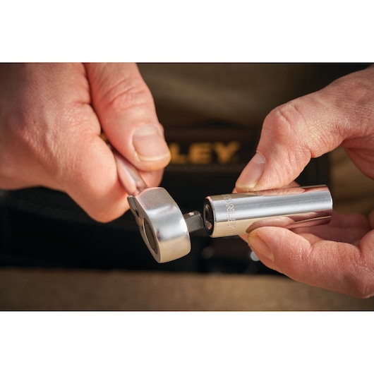 STANLEY STMT86099-0 socket wrench and chrome socket, close-up of hands holding tool.