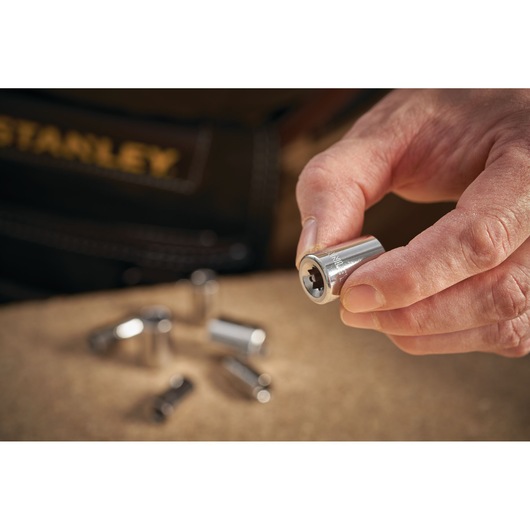 STANLEY STMT86111-0 socket held in hand, silver finish, other sockets blurred in background.