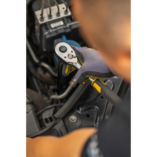 Photo of STANLEY STMT88930-0 ratchet being used on car engine, yellow and black handle visible.