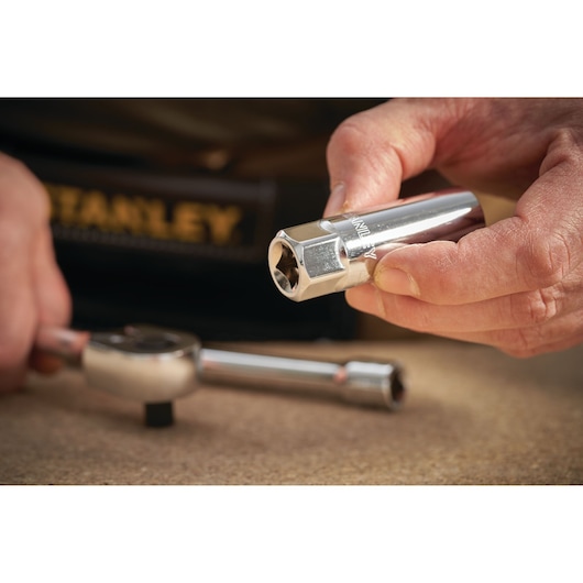 STANLEY STMT88941-0 socket held by hand, with ratchet wrench on table, close-up photography.