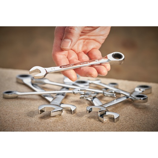 Photo of STANLEY STMT89917-0 ratcheting combination wrenches on work surface, one wrench held in hand.