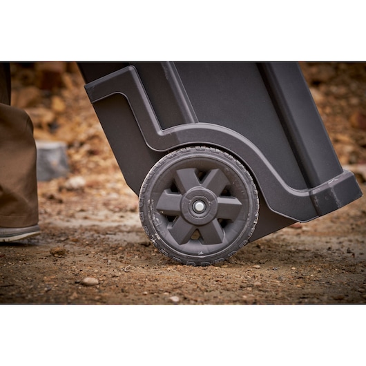 STANLEY STST1-79231 photography of black wheeled tool box wheel on rough outdoor surface.