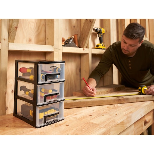STANLEY STST40711-1 three-drawer tool organizer on workbench, filled with hand tools, photography.