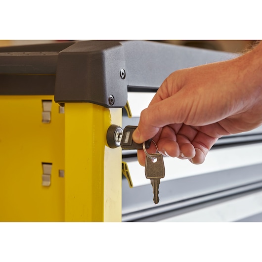 STANLEY STST74306-1 tool storage cabinet side view with hand inserting key into lock.