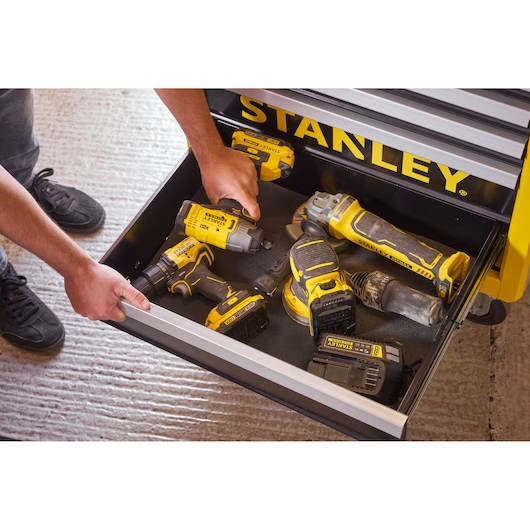 Photo of STANLEY STST74306-1 tools in a yellow drawer, including drill, sander, grinder and charger.