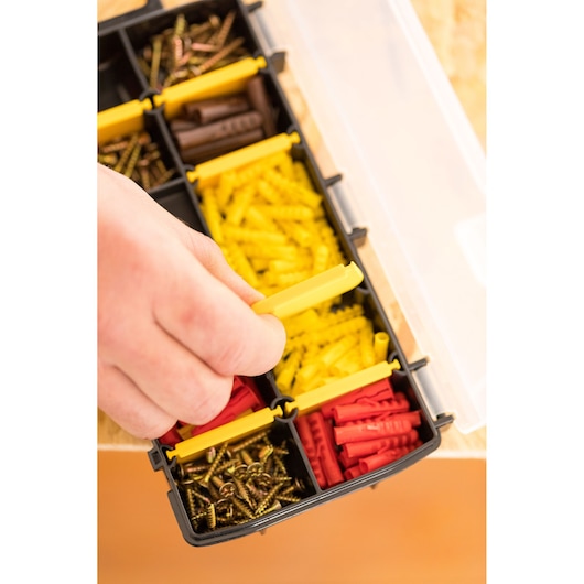 STANLEY STST81679-1 organizer with assorted screws and wall plugs, hand opening compartment, top view.