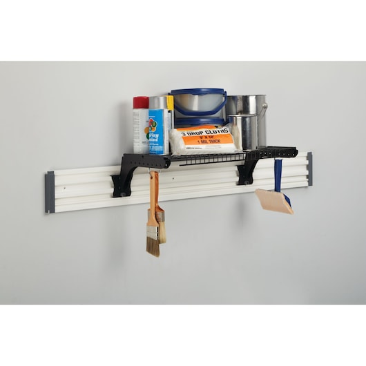 STANLEY STST82612-1 wall-mounted storage shelf with black wire shelf, holding paint supplies, front angle.