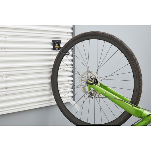 STANLEY STST82616-1 wall-mounted bike hook holding green bicycle, photography side angle.
