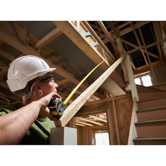 Photo of STANLEY XTHT0-33501 tape measure used on staircase in construction site.