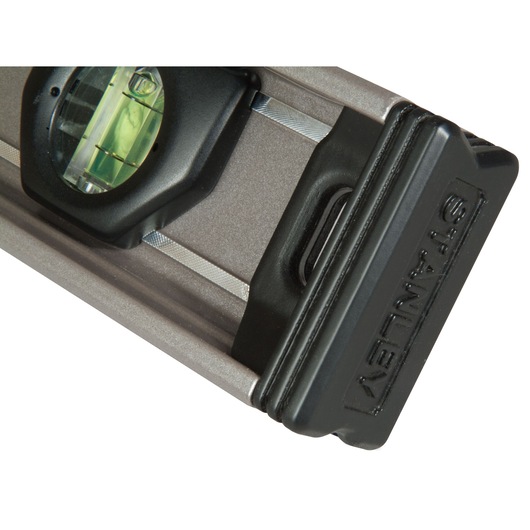 Close-up of a Stanley spirit level with a bubble vial and durable black end cap.