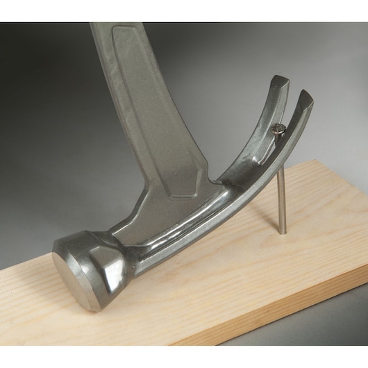STANLEY XTHT1-51148 hammer close-up on white background with nail held in wood.